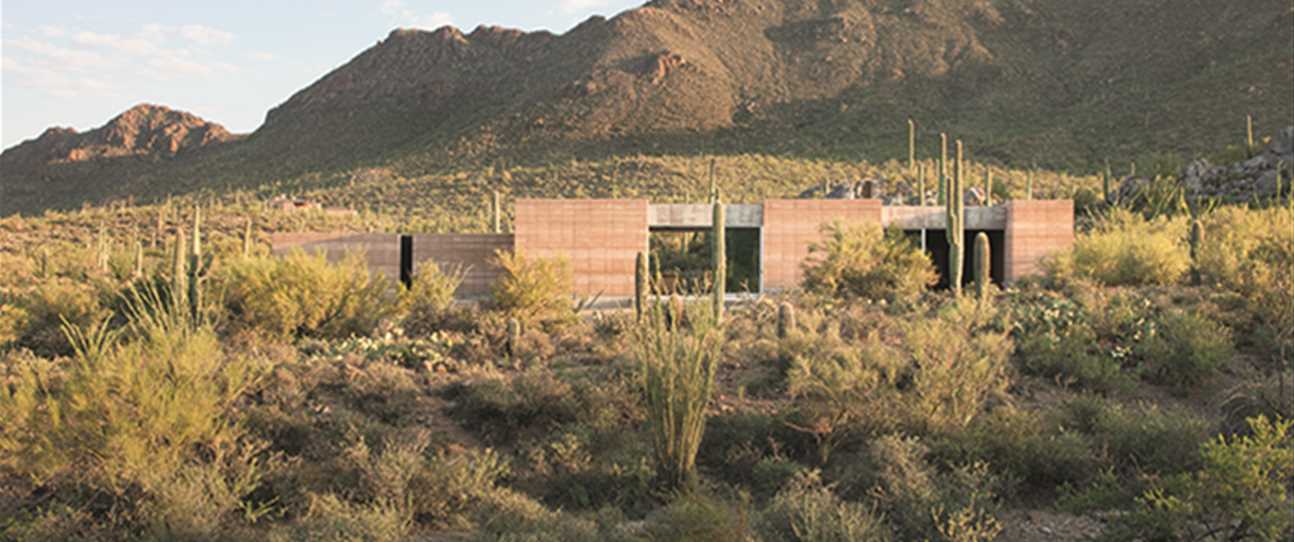PHOTOGRAPHY by Bill Timmerman. Located next to the Saguaro National Park in Tuscon, this holistic, rammed earth abode blends into its desert surroundings. Split into three different zones, the home boasts long, sweeping views of the park and its cact
