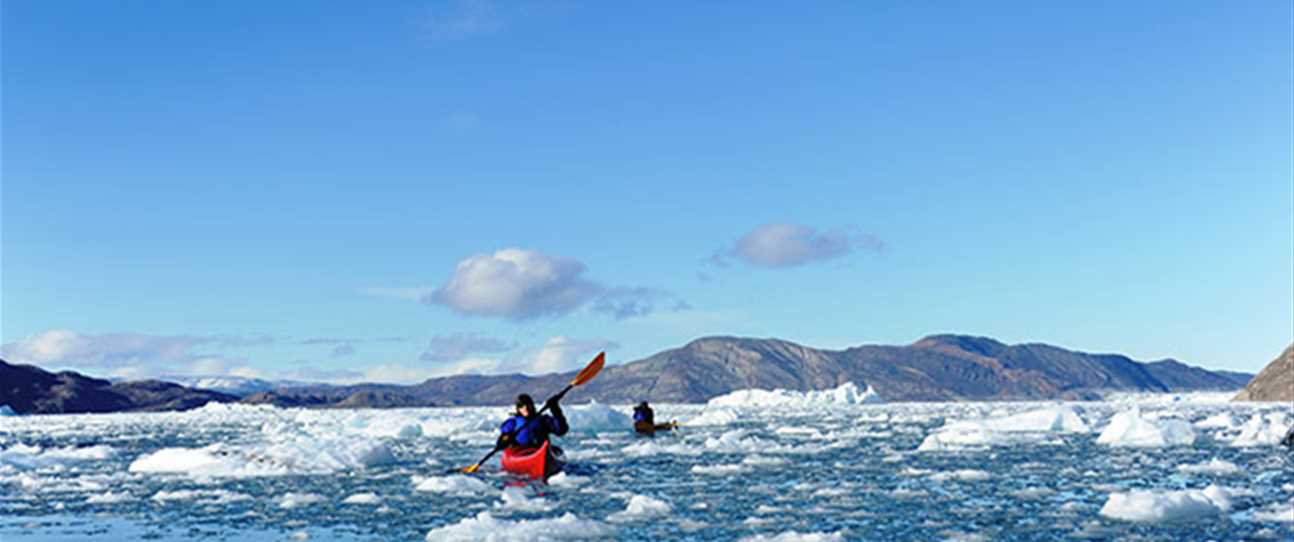 Sea kayaking through floating brash ice on the West coast of Greenland.