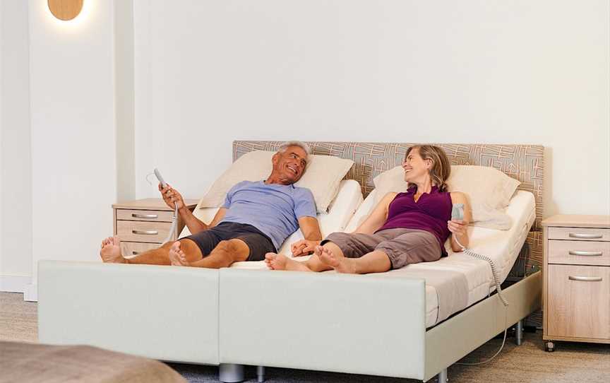 Happy couple enjoying a king size bed in the European Bedding showroom