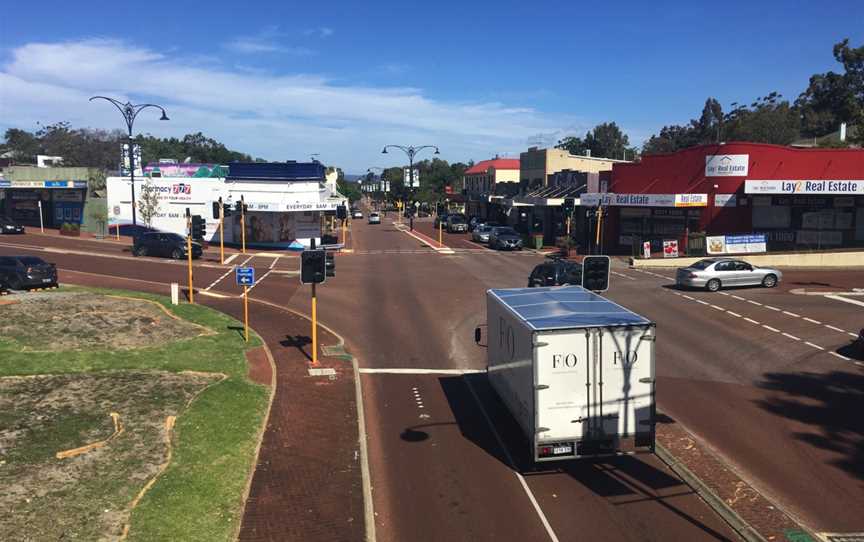 A photographic long shot of commercial buildings lining a road