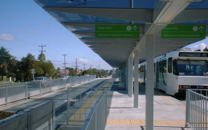 A tram station with a tram waiting for passengers