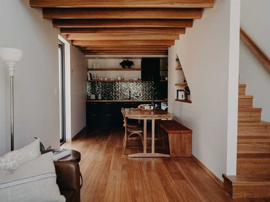 Downstairs living and dining rooms, lined with blackbutt timbers and fitted with handcrafted furniture.
