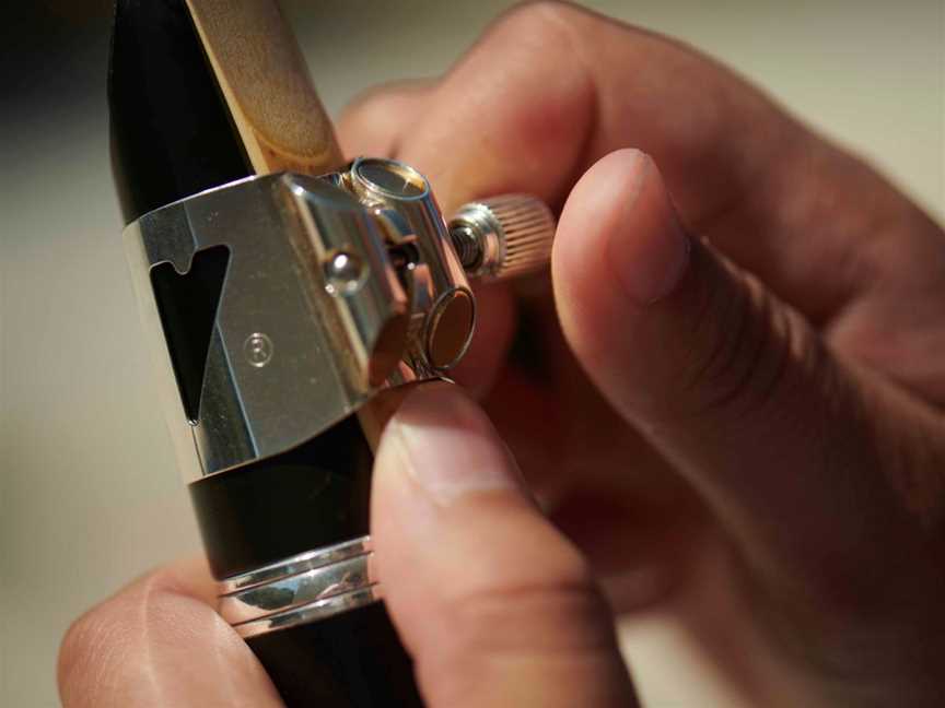A close-up shot of someone adjusting their clarinet mouthpiece