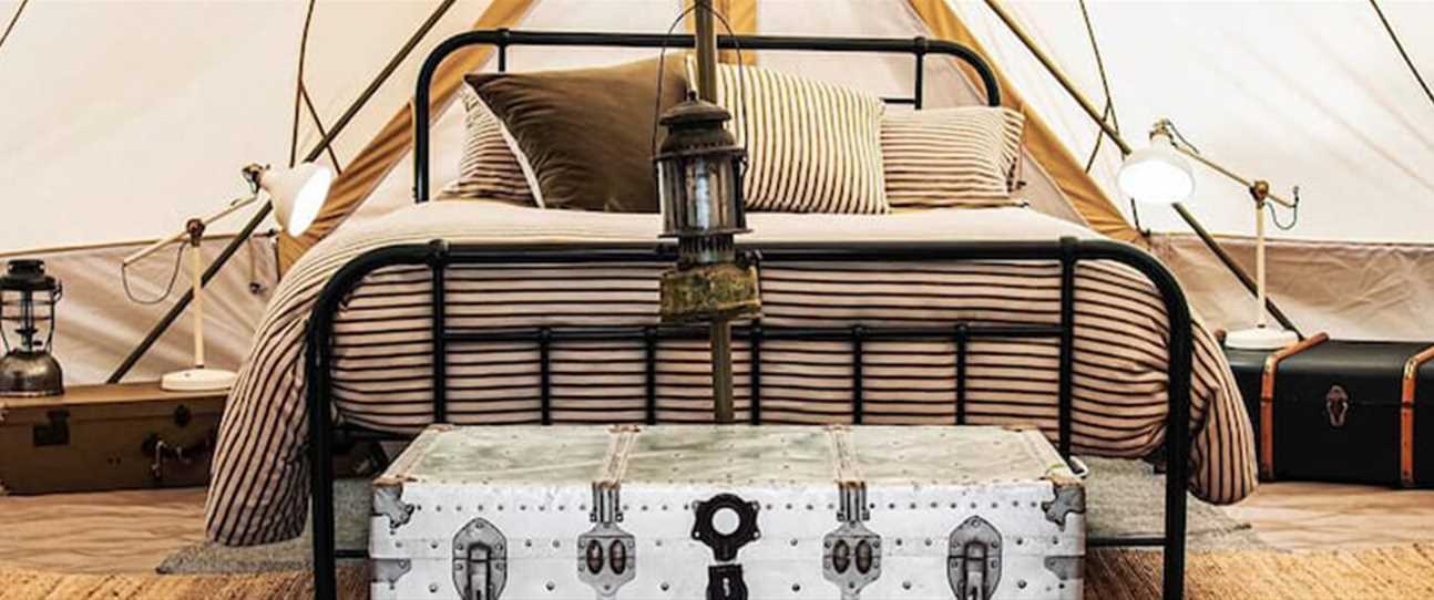 vintage style bed and trunk in tent